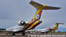 Newly acquired Uganda Airlines Bombardier CRJ900 aircraft stand on the runway at Entebbe Airport on the outskirts of Kampala on April 23, 2019. - The first two planes purchased in a bid to relaunch Uganda Airlines have been delivered, nearly two decades after the East African country's national carrier collapsed. The two Bombardier CRJ900 jet airliners, which can carry up to 90 people, landed at the Entebbe airport outside the capital Kampala during a ceremony attended by President Yoweri Museveni. (Photo by Nicholas BAMULANZEKI / AFP) (Photo credit should read NICHOLAS BAMULANZEKI/AFP/Getty Images)