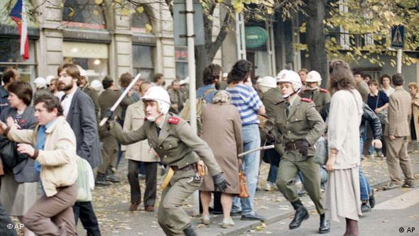 Policeman with baton chases student protestors in Prague, 1989