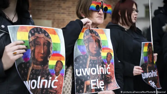Protesters holding up posters of rainbow madonna