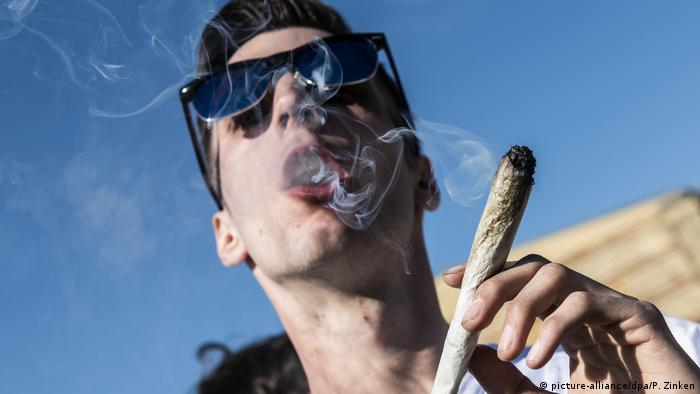 Ein junger Mann aus Berlin raucht aus medizinischen Gründen bei einer Protestaktion in Berlin für legalen Cannabis-Konsum einen übergroßen Joint. 
