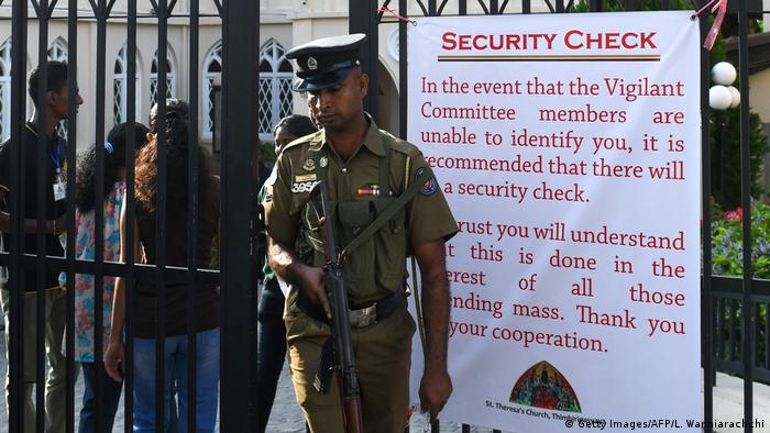 A Sri Lankan police officer stands guard at the main entrance of the St. Theresa's church as the Catholic churches hold services again after the Easter attacks in Colombo on May 12, 2019