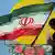 A Iranian woman walks past a wall painting in the shape of Iranian flag in Tehran