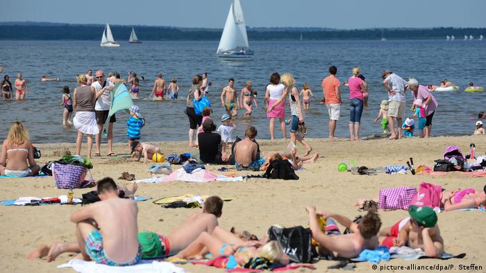 People sunbathing and swimming at the beach of the Steinhuder Sea, Germany