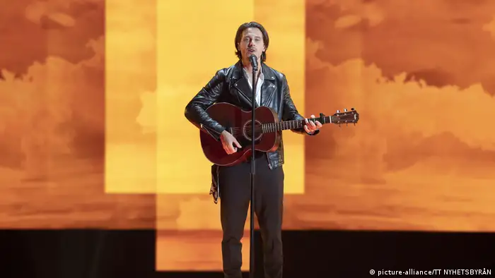 Eurovision Song Contest 2019 | Man with guitar before an amber, cloudy background (picture-alliance/TT NYHETSBYRÅN)