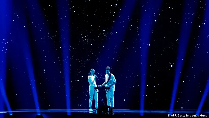 Female singer and male guitarist in white on a stage set suggesting a starry night (AFP/Getty Images/J. Guez)