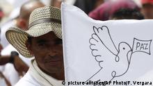 FILE - In this June 27, 2017 file photo, a rebel of the Revolutionary Armed Forces of Colombia, FARC, waves a white peace flag during an act to commemorate the completion of their disarmament process in Buenavista, Colombia. FARC leader Carlos Lozada announced that starting Sept. 1, 2017, the rebel group will convert into a legal political movement. (AP Photo/Fernando Vergara, File) |
