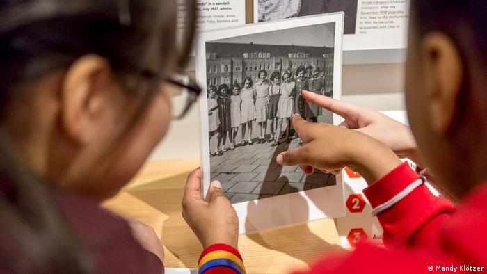 Kinder betrachten ein Schwarz-Weiß-Foto von Anne Frank