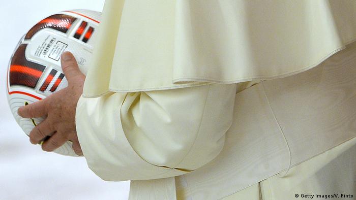Papst Franziskus hält einen Fußball