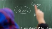 ARCHIV - 05.02.2015, Hessen, Frankfurt/Main: Eine Schülerin mit Kopftuch meldet sich an einer Schule bei einer Unterrichtsstunde zum Thema Islam. (zu «Regionalkonferenz «Die Vielfalt des Islam an Brandenburger Schulen»») Foto: Frank Rumpenhorst/dpa +++ dpa-Bildfunk +++ | Verwendung weltweit