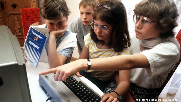 Kids sitting at an older computer C 64 (picture-alliance/dpa/K. Staedele)
