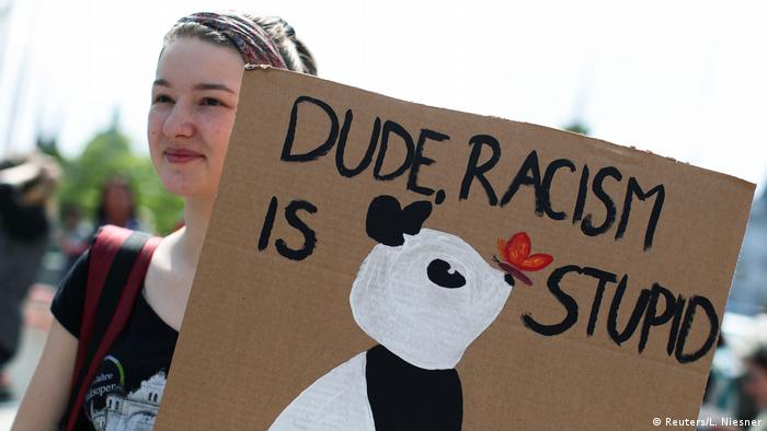 An Austrian rally participant holds a sign that says Dude, racism is stupid (Reuters/L. Niesner)
