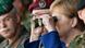 Merkel with military officers looking through binoculars Merkel with military officers looking through binoculars