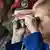 Merkel with military officers looking through binoculars