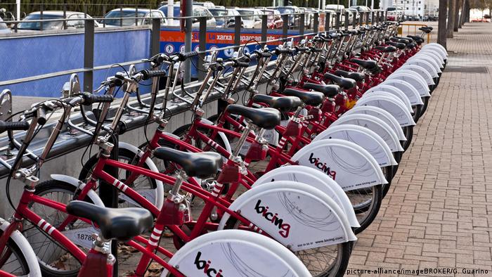 A bicycle hire center with red bikes parked in a row in Barcelona in Spain