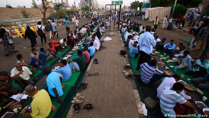 Protesters sit in rows on the ground while breaking fast (Getty Images/AFP/A. Shazly)