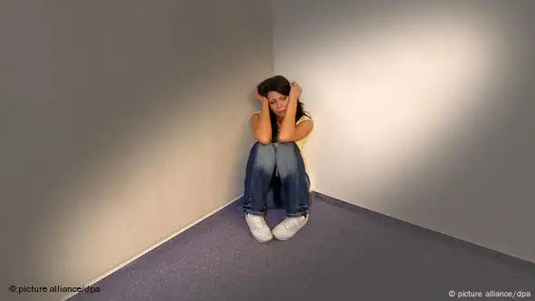 Ängstliche, depressive Frau sitzt in der Ecke eines Zimmers (Foto: picture alliance/dpa)