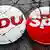 Anstecker der Volksparteien CDU und SPD auf brüchigem Grund
