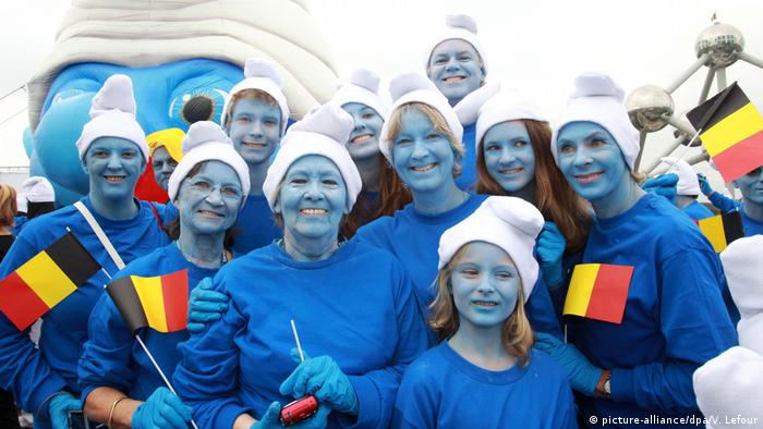 Eine Gruppe von Leuten mit belgischen Fahnen posieren als Schlümpfe
