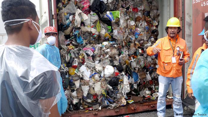 Philippines customs officials inspecting garbage shipped by Canada