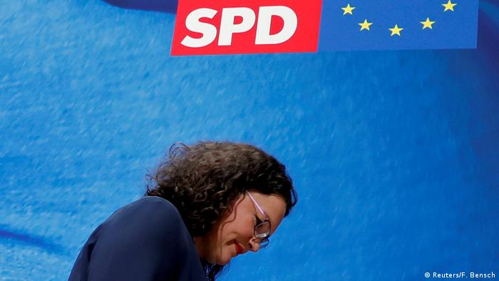 Andrea Nahles of the SPD walks with her head down under an SPD symbol