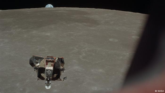 The lunar module of the Eagle can be seen on its return from the Moon;  behind it, you can see the lunar surface and, on its horizon, the Earth
