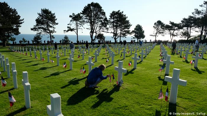 A visitor attends a cross at the Normandy American Cemetery on the 75th anniversary of D-Day.