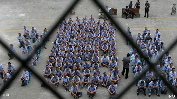 Police officers guard as inmates attend a meeting at the Nanbaoshan Prison in Qionglai, in China's southwest Sichuan province Tuesday June 13, 2006. Teachers from Chengdu Vocational School came to the prison to give the inmates technology lessons, to help them with future job hunting. (AP Photo/Color China Photo) ** CHINA OUT **