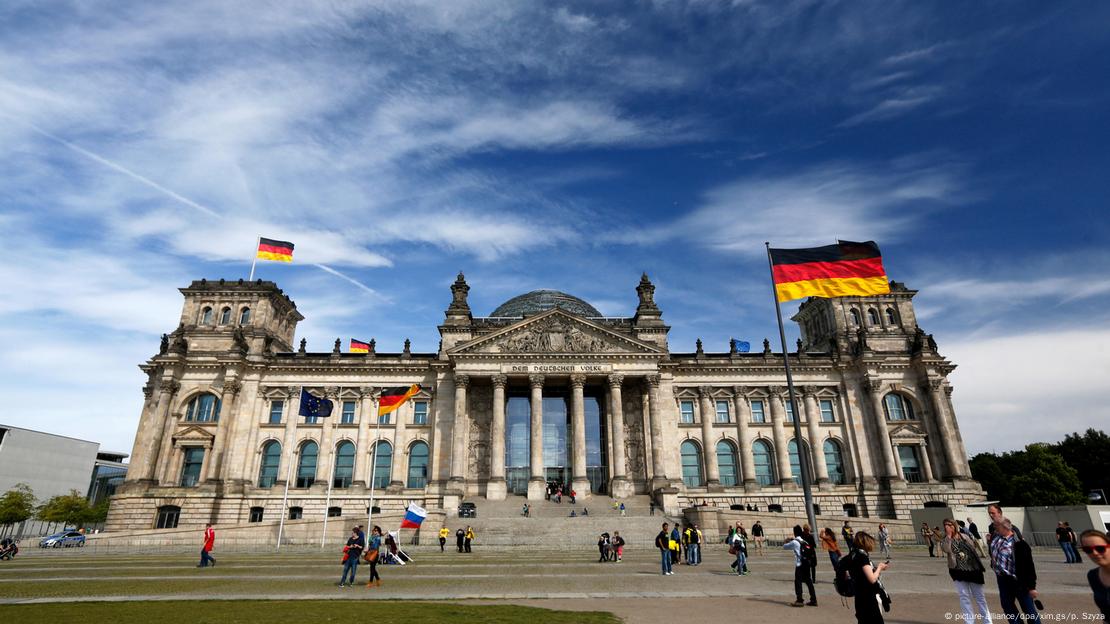Le Reichstag photographié de face à Berlin avec des drapeaux allemands flottant devant et au-dessus