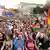 Multidão nas ruas de Varsóvia com bandeiras arco-íris