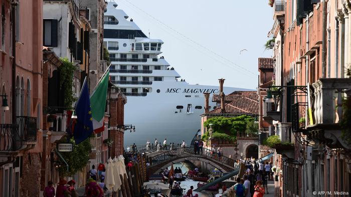 A cruise ship is seen from one of the canals leading to the lagoon in Venice, Italy
