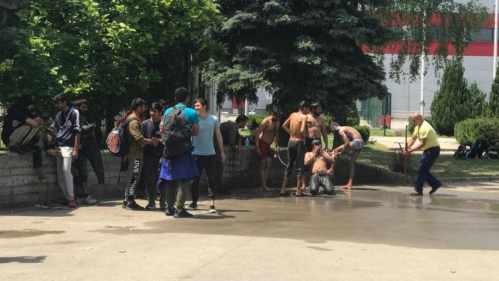 Migranten waschen sich vor dem Flüchtlingscamp Bira