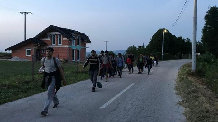 Migranten in der Dämmerung auf dem Weg zur kroatischen Grenze