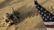 FILE - This Jan. 25, 2003 file photo shows an US soldier lying with his rifle in front of an American flag that hangs from a Humvee during live fire exercises in the Kuwaiti desert south of Iraq. Thousands of troops are assembling in Kuwait ahead of possible war with Iraq. President Barack Obama is poised to become the first U.S. leader in three decades to attack a foreign nation without broad international support or in direct defense of Americans. Not since President Ronald Reagan ordered an invasion of the Caribbean island of Grenada in 1983 has the U.S. been so alone in pursuing major lethal military action beyond a few attacks responding to strikes or threats against its citizens. (AP Photo/Laura Rauch, File) |