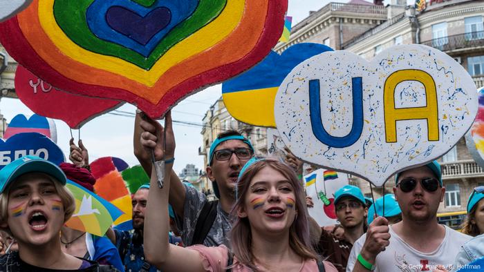 a group of people smiling and holding signs at the 2019 Pride march in Kyiv a group of people smiling and holding signs at the 2019 Pride march in Kyiv