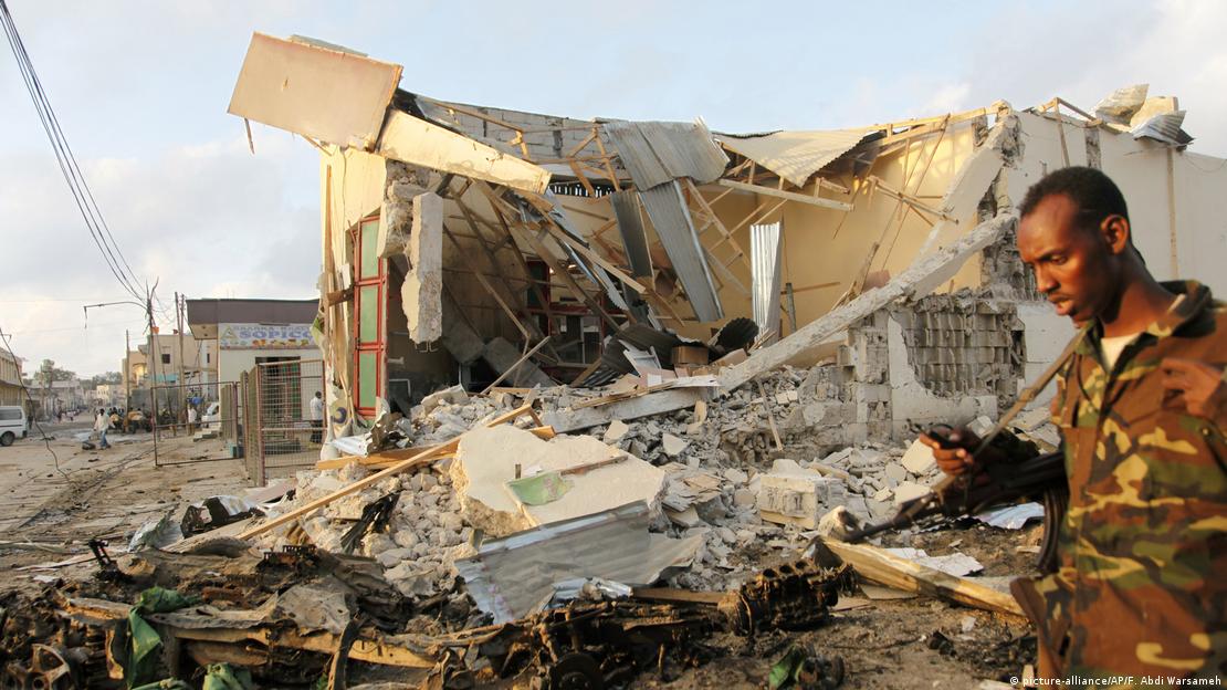 A soldier walks near destroyed buildings A soldier walks near destroyed buildings