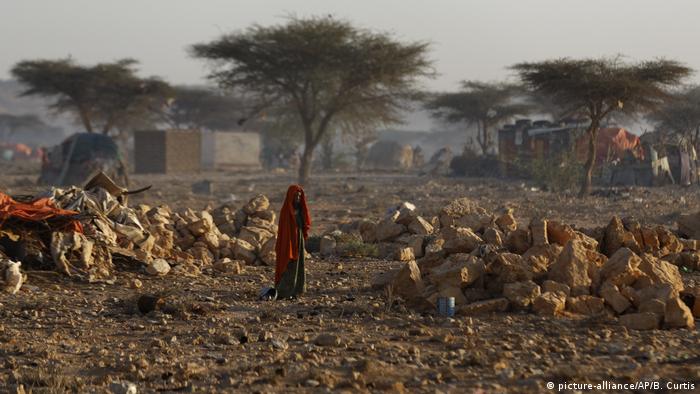 A Somali woman walks through a camp of people displaced from their homes elsewhere in the country by the drought