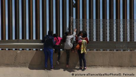 Migrants take a peek into the US city of El Paso from the Mexican city of Juarez