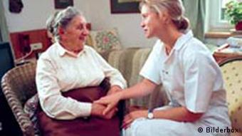 A care worker sitting with an elderly woman
