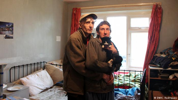 A couple with their cat in their flat