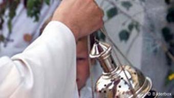 Katholischer Priester mit Weihrauch