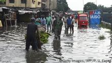 People walk on a flooded road at Okokomaiko in Ojo district of Lagos, on May 31, 2017. A torrential rainfall has left many homes, shops and roads flooded in Lagos, Nigeria's commercial capital / AFP PHOTO / PIUS UTOMI EKPEI (Photo credit should read PIUS UTOMI EKPEI/AFP/Getty Images)