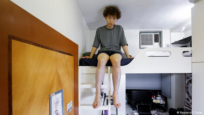 25-летний графический дизайнер Фан Чен сидит на лестнице, свесив ноги 