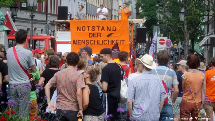 Demonstrators holding up placard (Imago Images/M. Westermann)