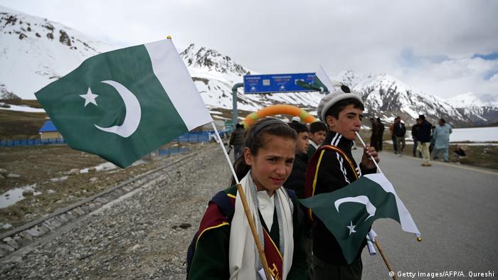 Pakistani children hold the national flag of Pakistan