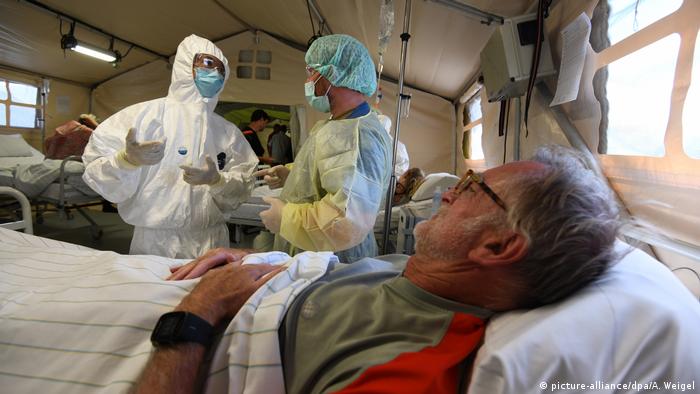 A Chinese and German soldier discuss next to a patient (picture-alliance/dpa/A. Weigel)