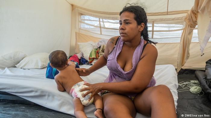 A woman with her baby in a tent