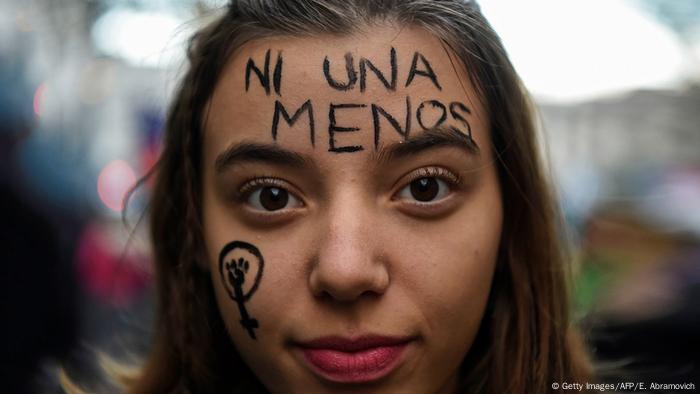 Foto simbólica de una mujer que lleva la frase ni una menos en su cara.