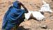A woman sits while waiting for food to be distributed in Kenya A woman sits while waiting for food to be distributed in Kenya