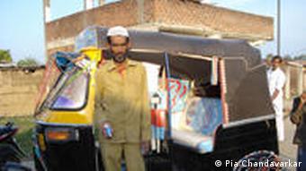 Rikschafahrer Irshad Ali steht vor seinem Wagen. In der Hand: sein Atemgerät. (Foto: Chandavarkar)
