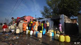 Menschen stehen mit Kanistern für Trinkwasser an (Foto: AP)